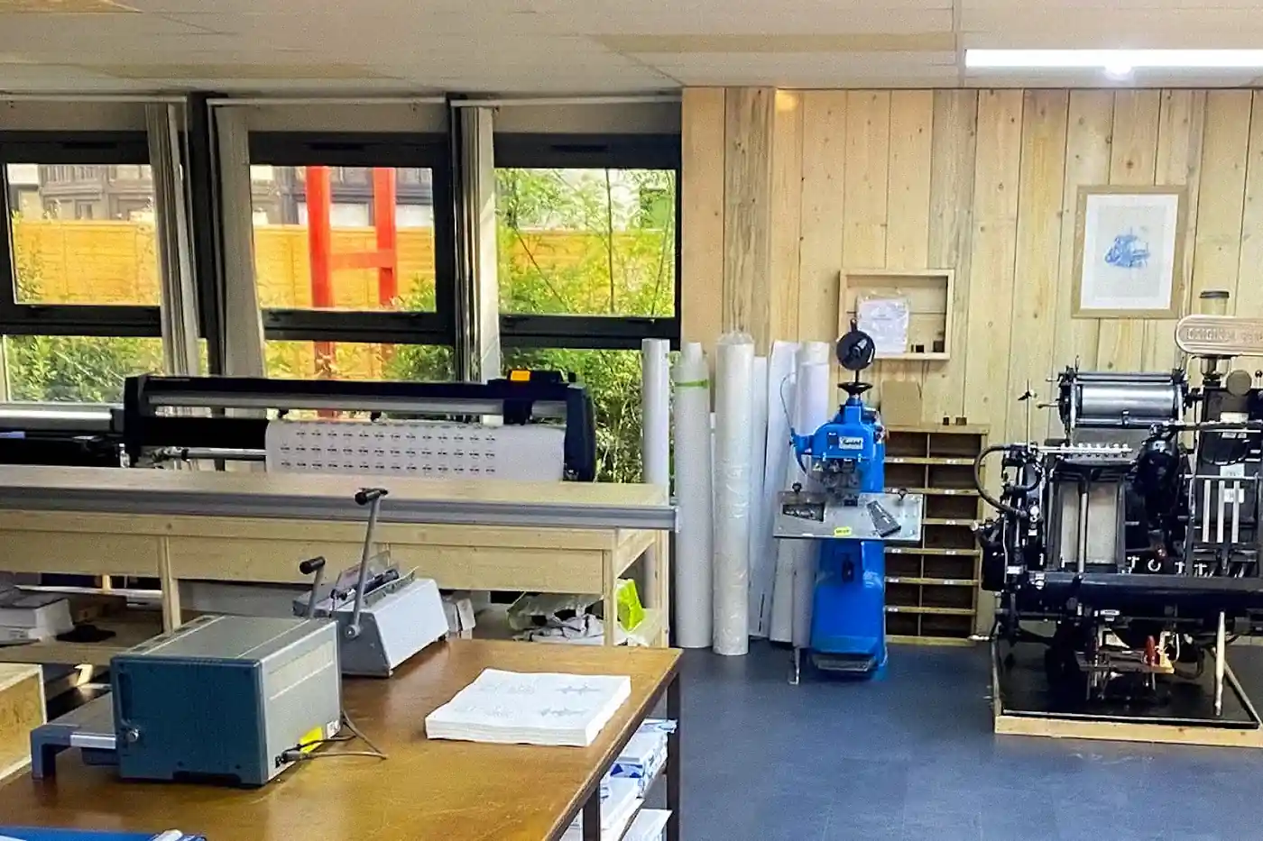 Atelier de l'Imprimerie Végétale à Magny-les-Hameaux : traceur grand format, presse typographique et tables de façonnage